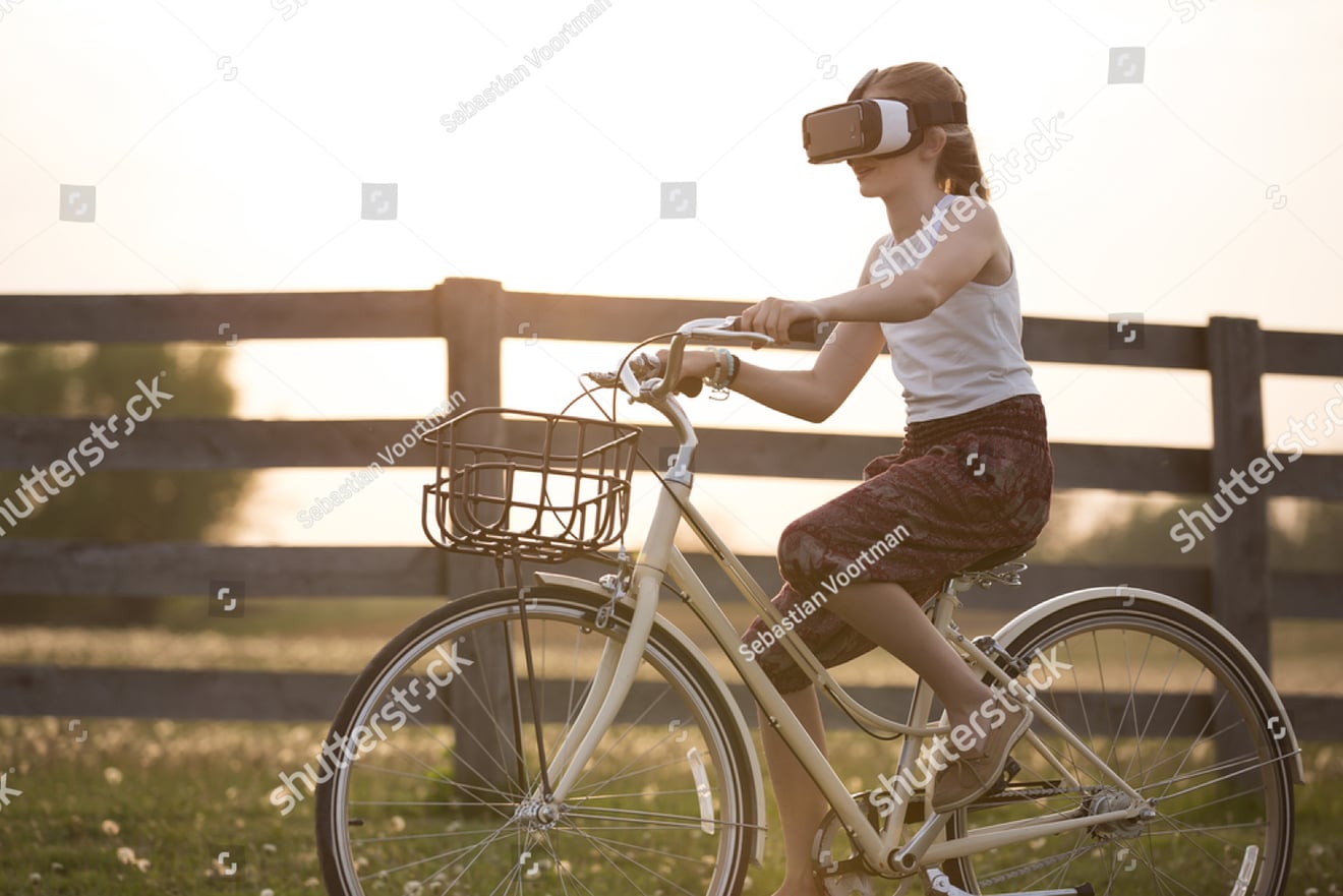 Woman riding bicycle while wearing VR headset